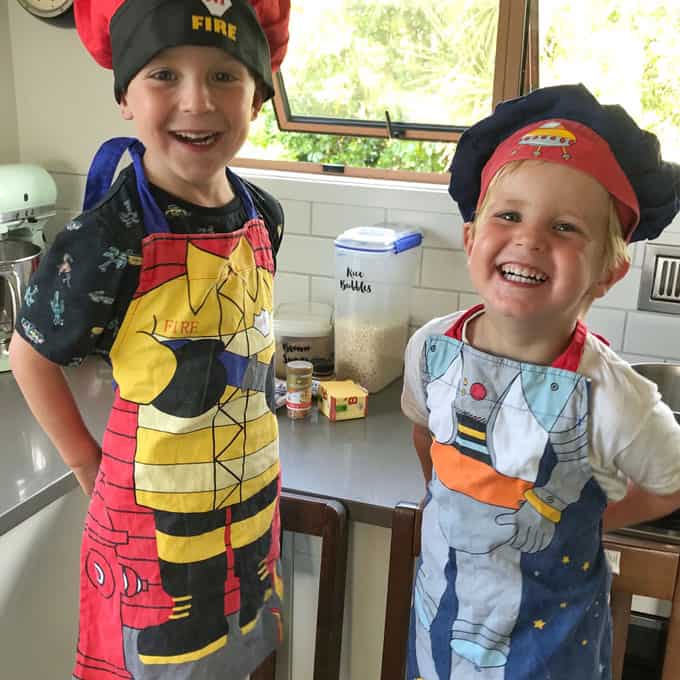 Kids in the kitchen with aprons and hats 