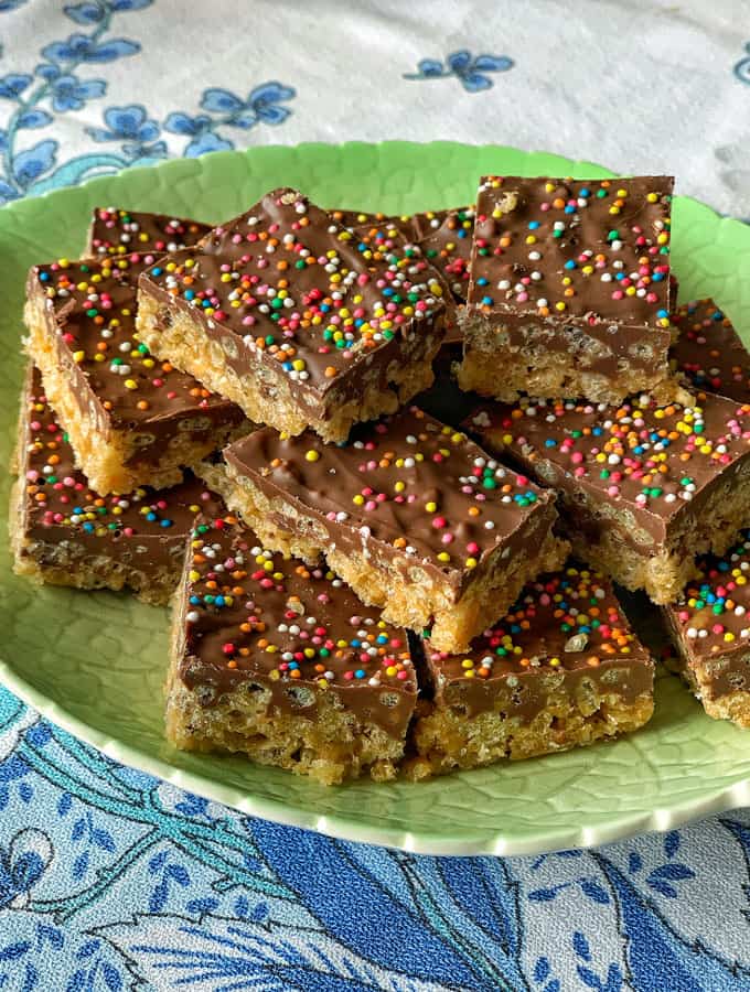 rice bubble slice on a plate with chocolate topping and sprinkles 