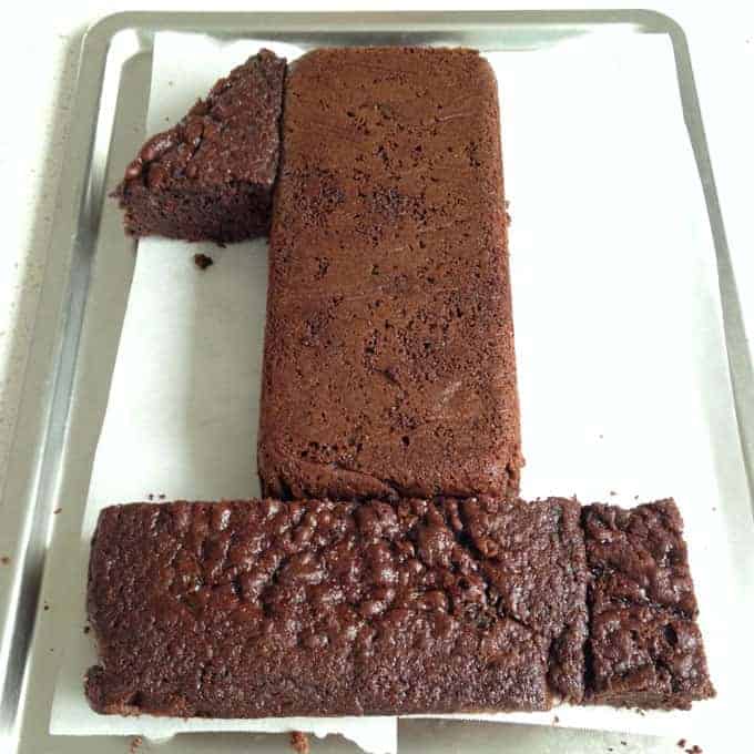 Pieces of chocolate cake in the shape of a number one on a tray.