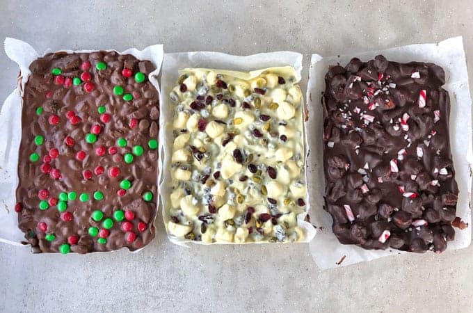 Christmas rocky road 3 ways sitting on a grey bench.