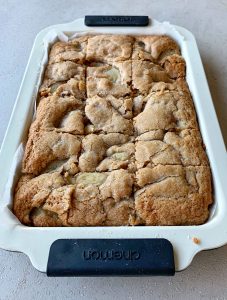 Easy Apple Slice, cooked and sliced in a slice tray on a grey bench.