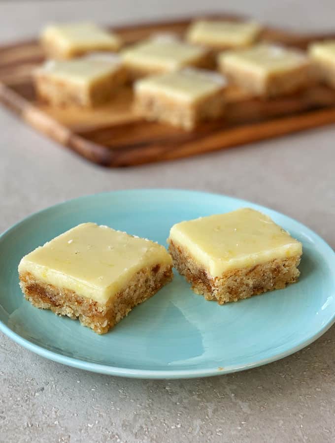 Two pieces of Lemon Weetbix Slice on a blue plate.