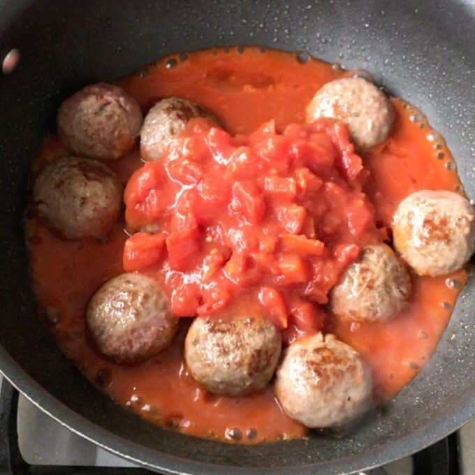 One Pot Baked Meatballs and Pasta One Pot Baked Meatballs and Pasta simmer in a pan with chunky tomato sauce on the stovetop, creating a cozy and flavorful meal.