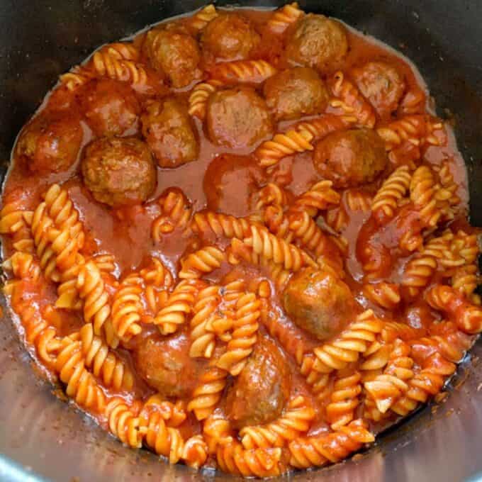 One Pot Baked Meatballs and Pasta A pot of One Pot Baked Meatballs and Pasta features rotini mixed with tomato sauce and evenly distributed meatballs.