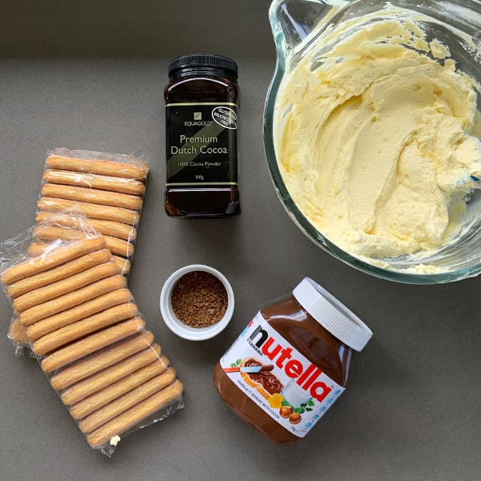 The ingredients for Nutellamisu sitting on a grey bench.