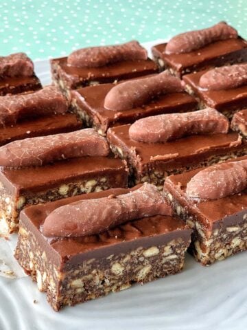Rectangular Chocolate Fish Slice biscuit slices topped with a chocolate finger on each piece, arranged neatly on a white tray.