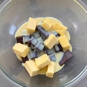 Easter Egg Slice Chopped butter and chocolate pieces with condensed milk in a glass bowl come together to create a rich Easter egg slice.