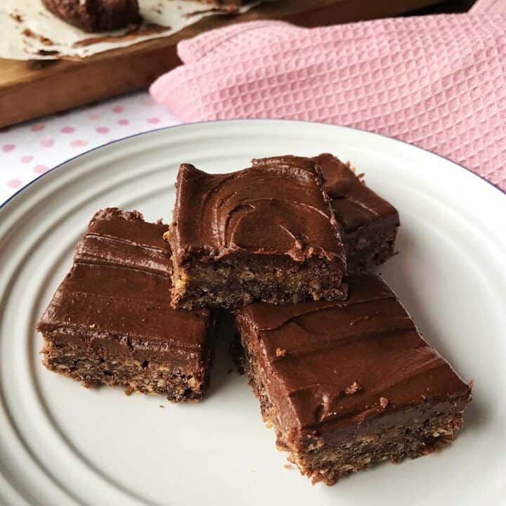 Three pieces of Chocolate Weetbix Slice sitting on a white plate.