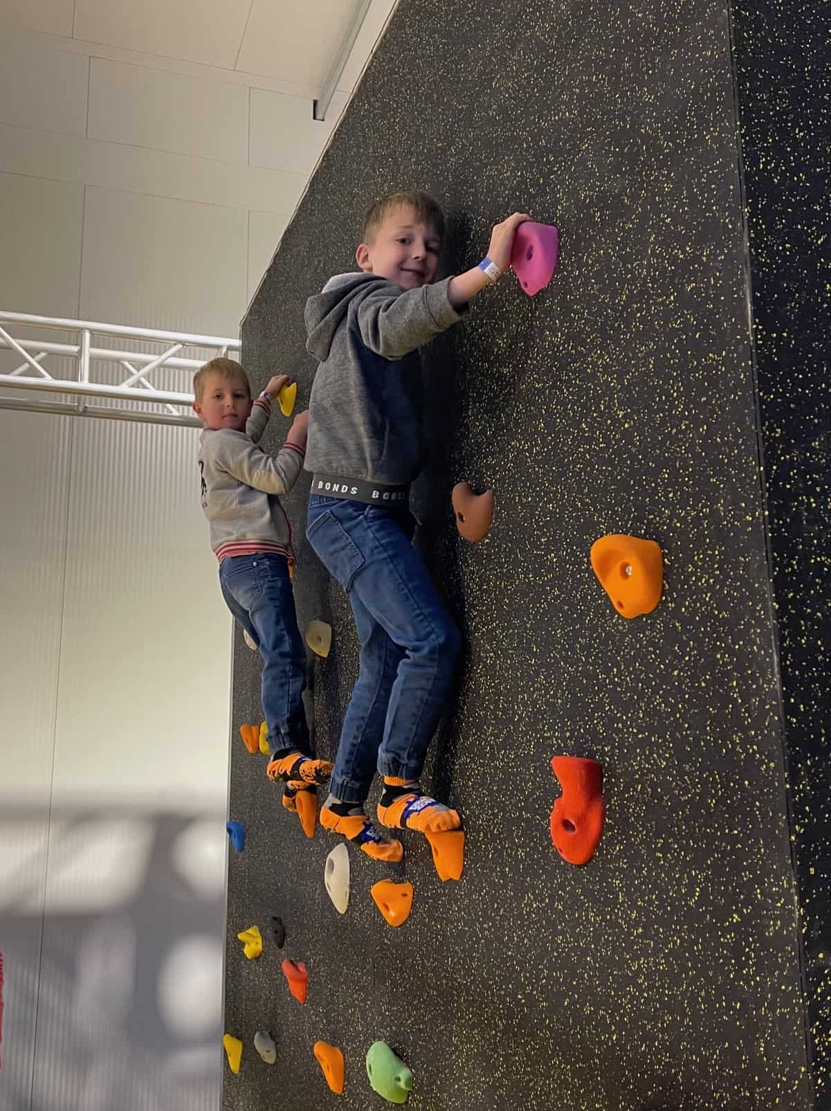 Two boys on a climbing wall.