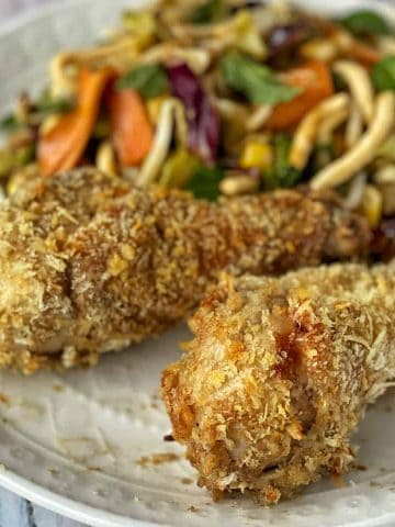 crispy chicken drumsticks on a plate with coleslaw