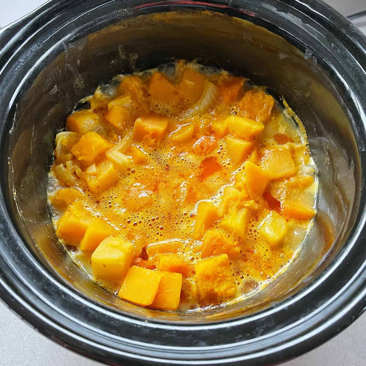 Pumpkin Soup cooking in a black slow cooker.