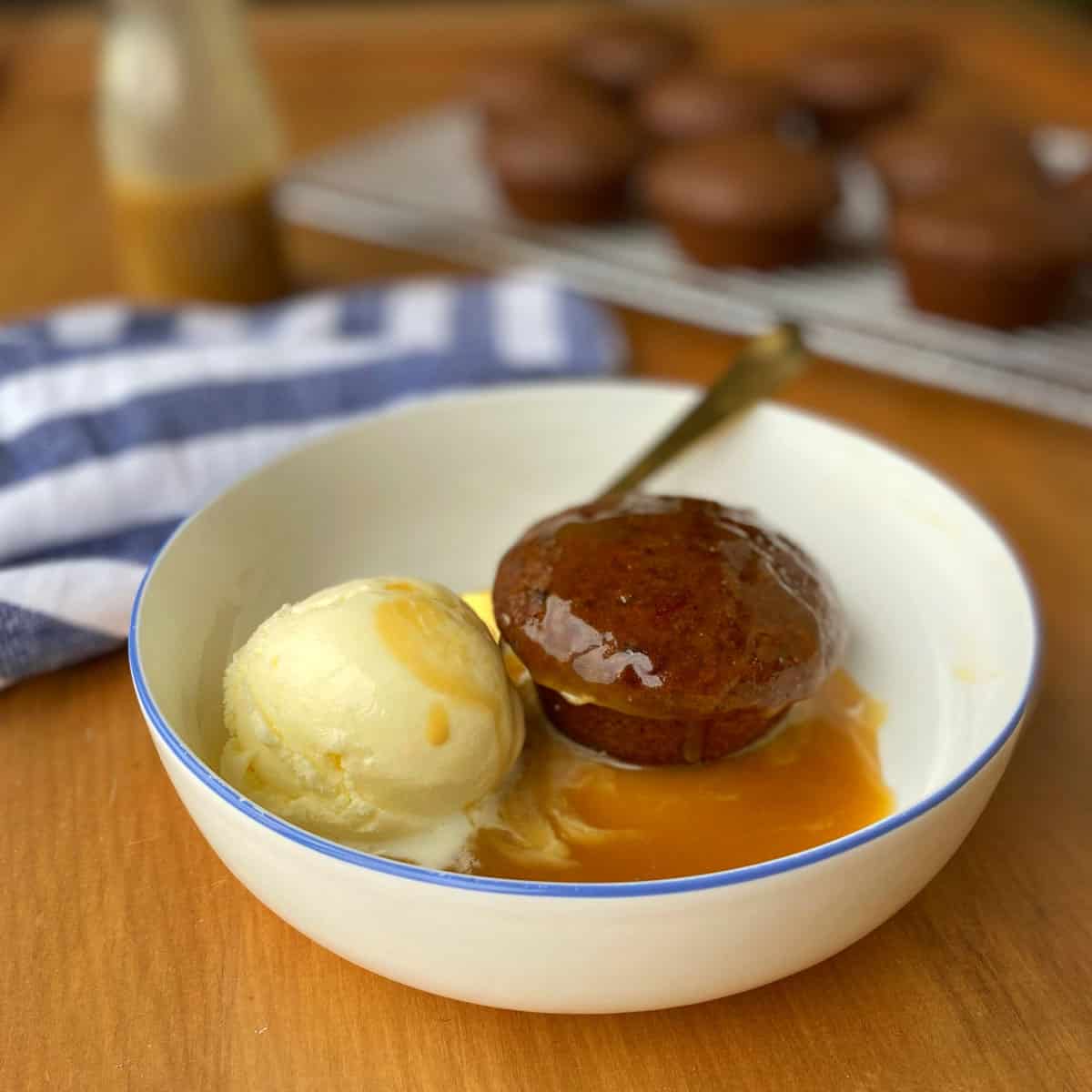 Mini sticky date pudding with icecream in a white bowl.