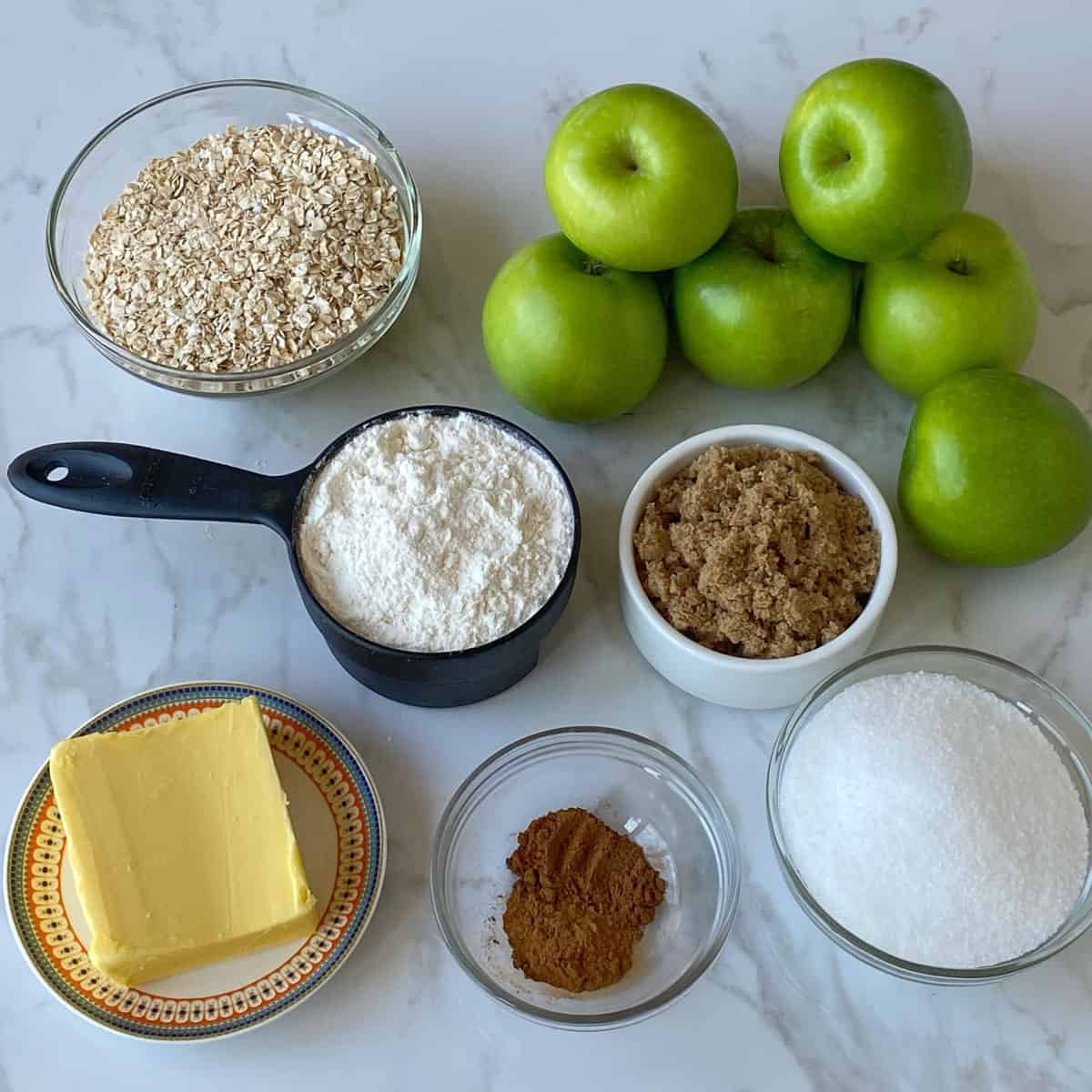 Ingredients used to make apple crumble on a bench.