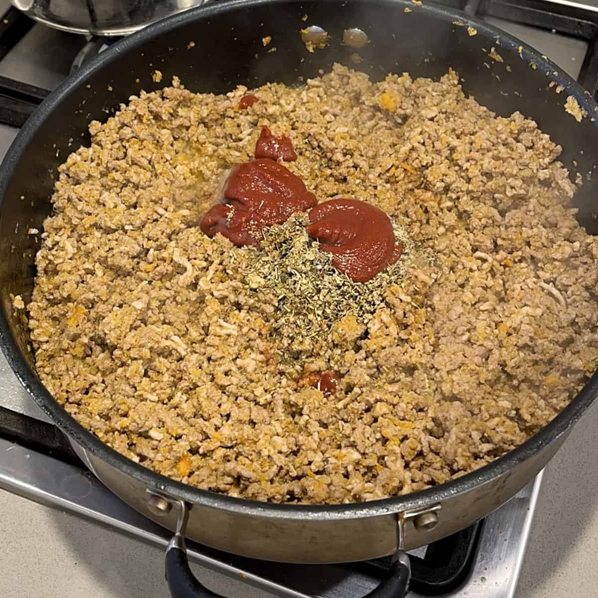 Mince and tomato paste in a fry pan.