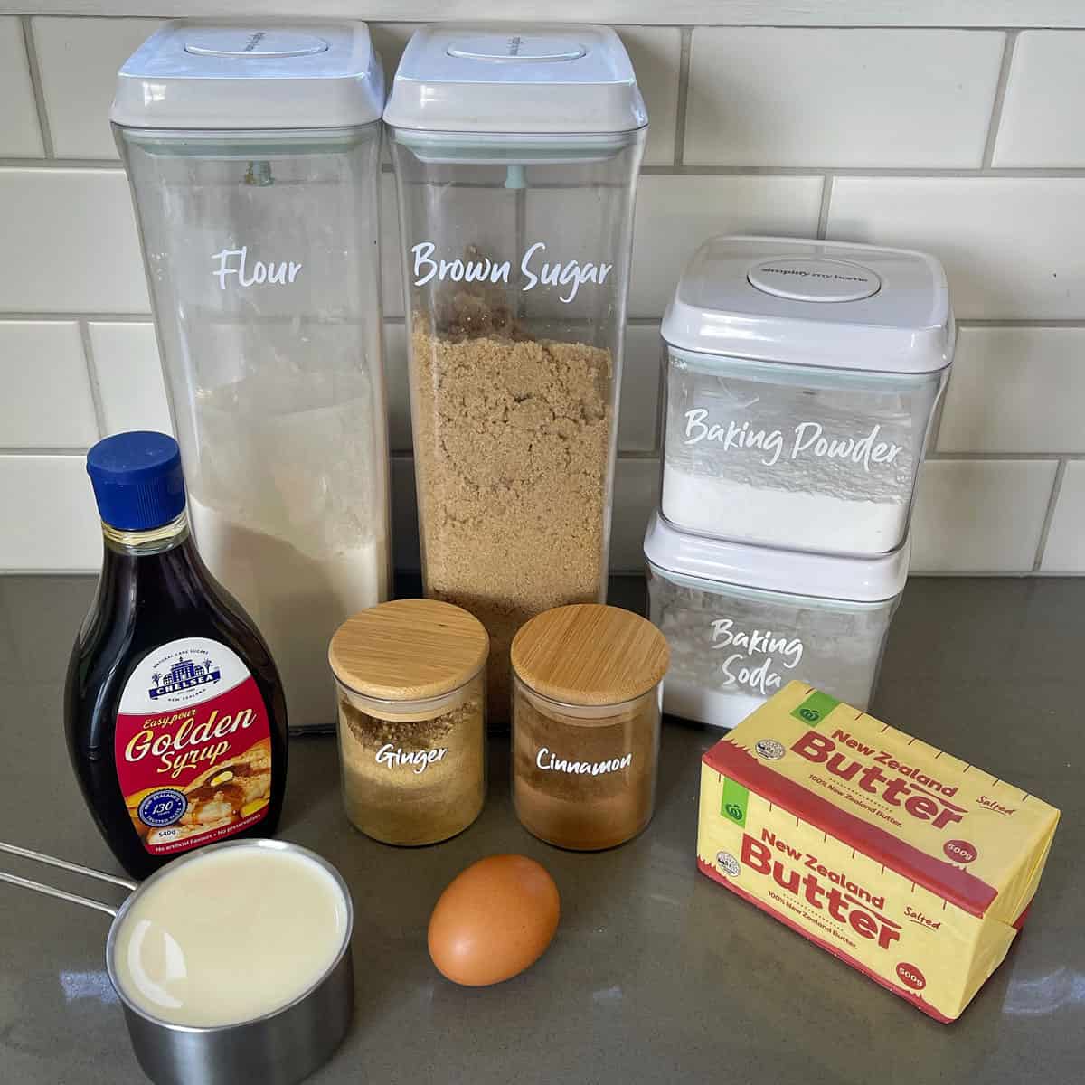 Ingredients for gingerbread loaf on a grey bench.