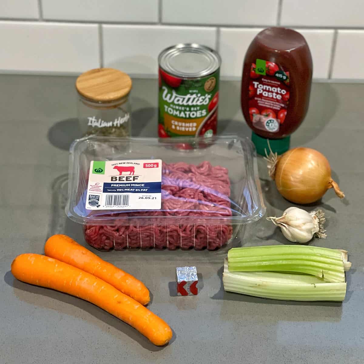 Ingredients for Spaghetti Bolognese on a grey bench