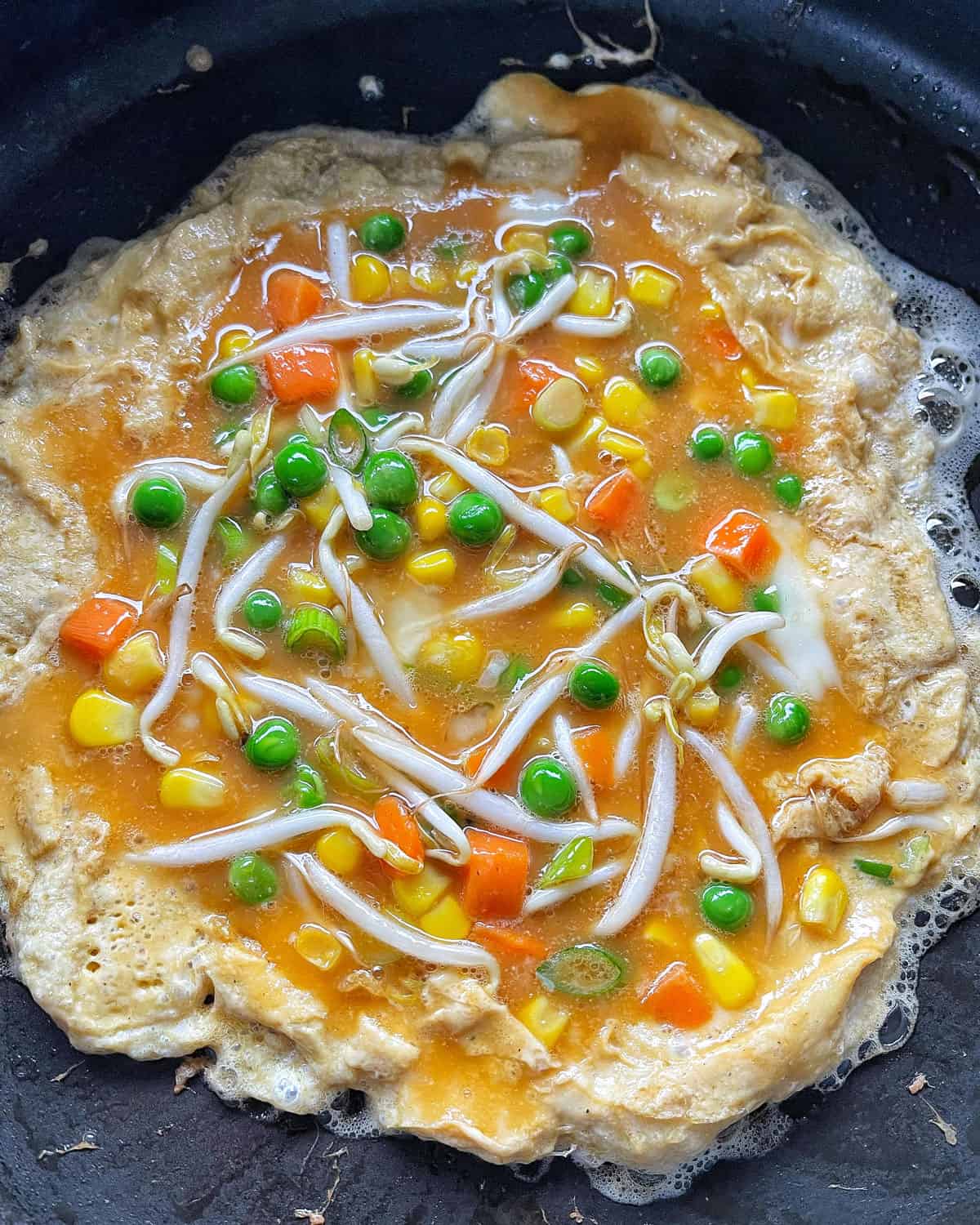 Egg Foo Young cooking in a frying pan