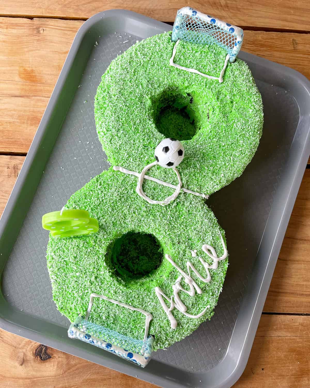 A number 8 birthday cake with green icing decorated to look like a football pitch.