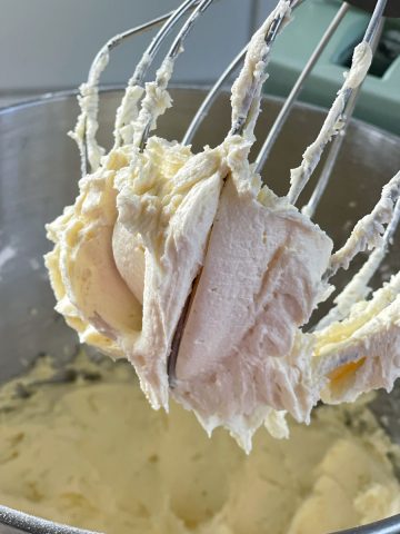 Buttercream icing being made in a stand mixer.