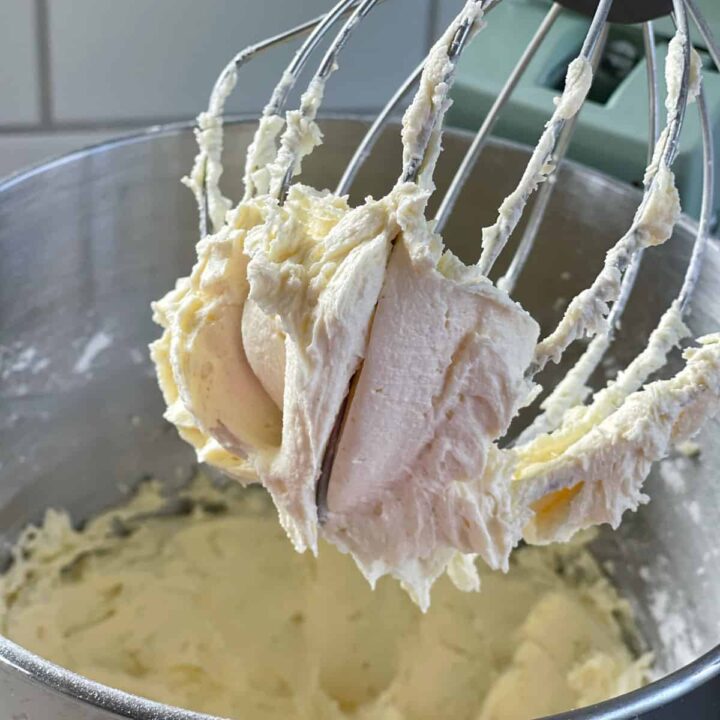 Buttercream icing being made in a stand mixer.