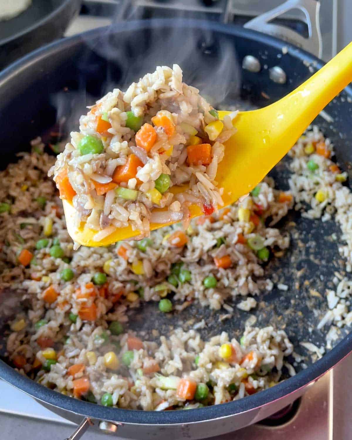 Mushroom Fried Rice being stirred in a frying pan.