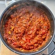 Pasta sauce in a large frying pan on grey bench.