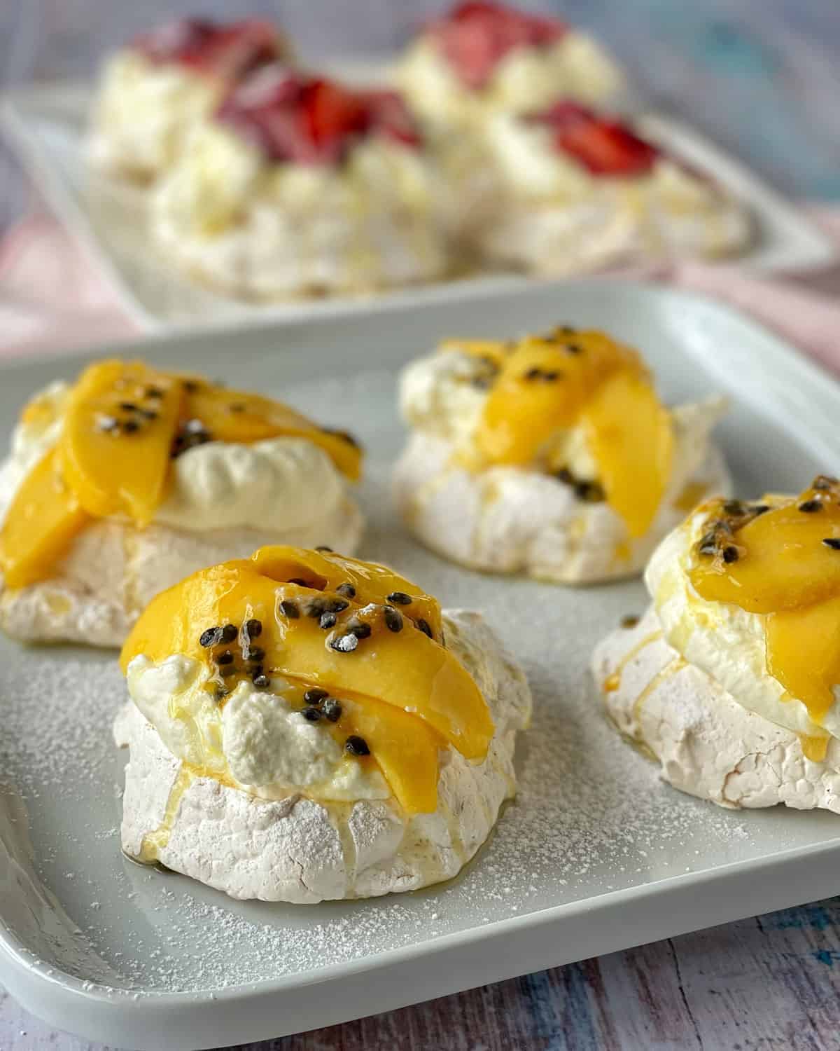 A close up of Mini tropical pavlovas sitting on a white plate