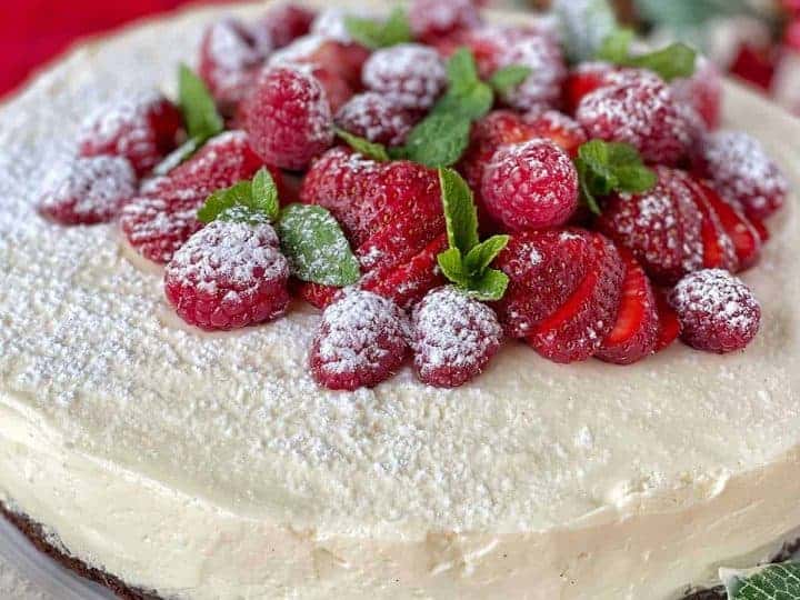 White chocolate mousse cake sitting on a white plate.