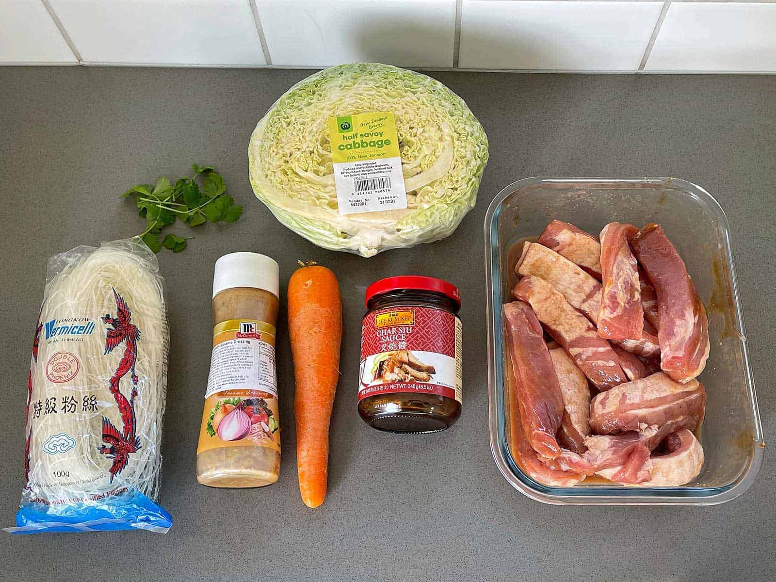 The ingredients for Chinese Pork with Noodles sitting on a grey bench.