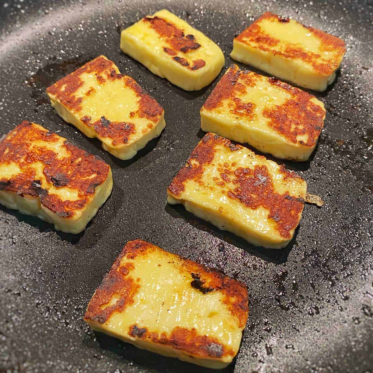 Haloumi cooking in a frying pan.