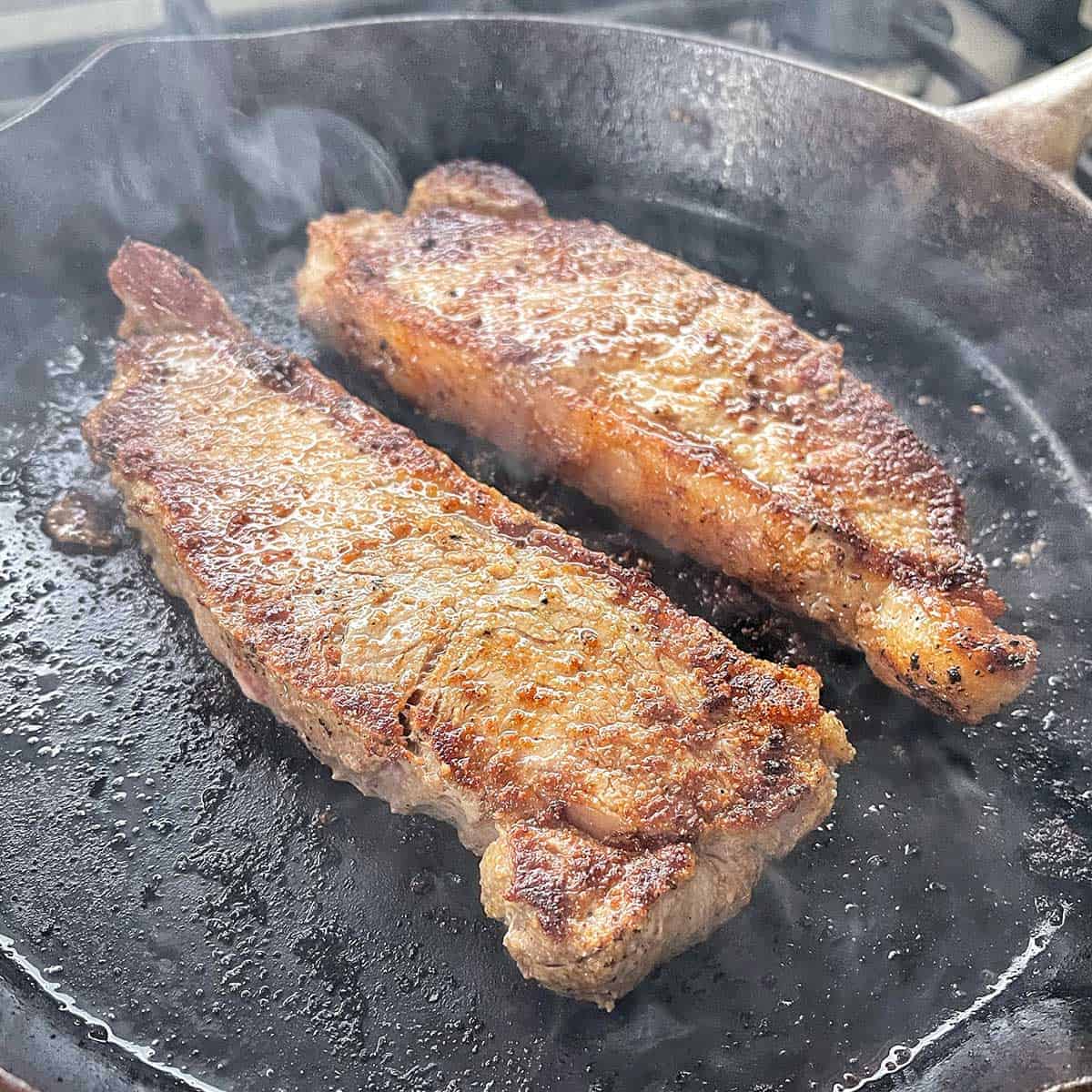 Steak frying in a pan