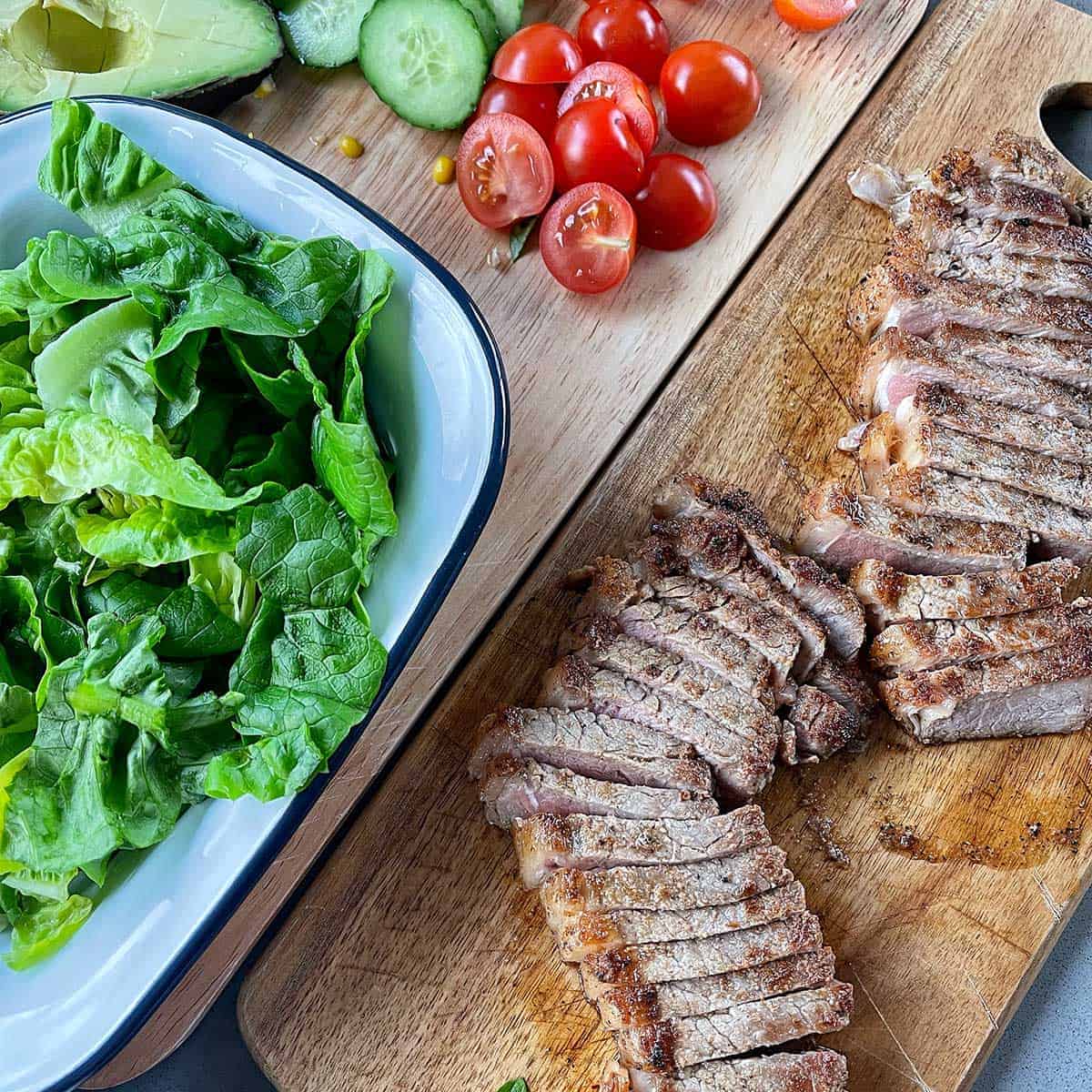 Sliced steak on a board.