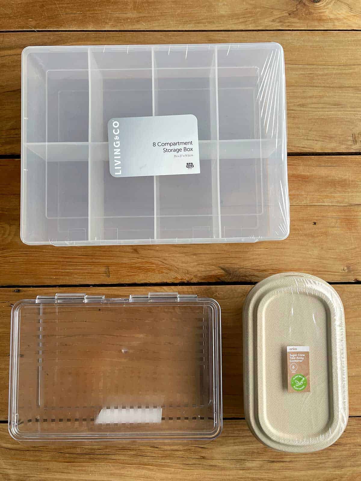 Three containers of various shapes and sizes sitting on a wooden bench.