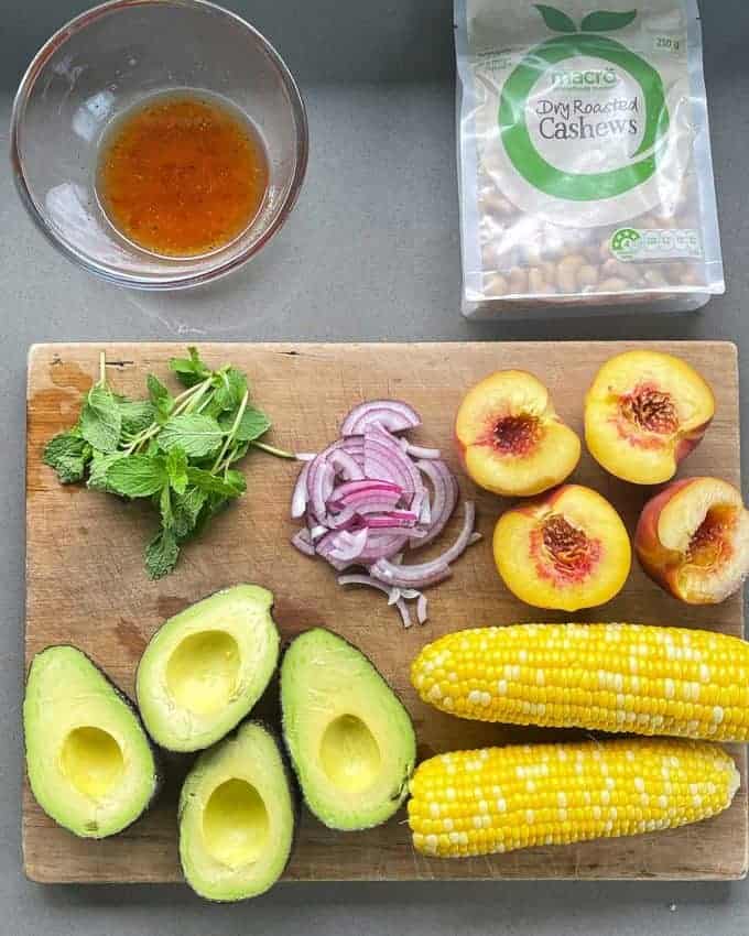 Grilled Pork, Peach and Corn Salad The ingredients for Corn, Peach and Pork Salad on a grey bench