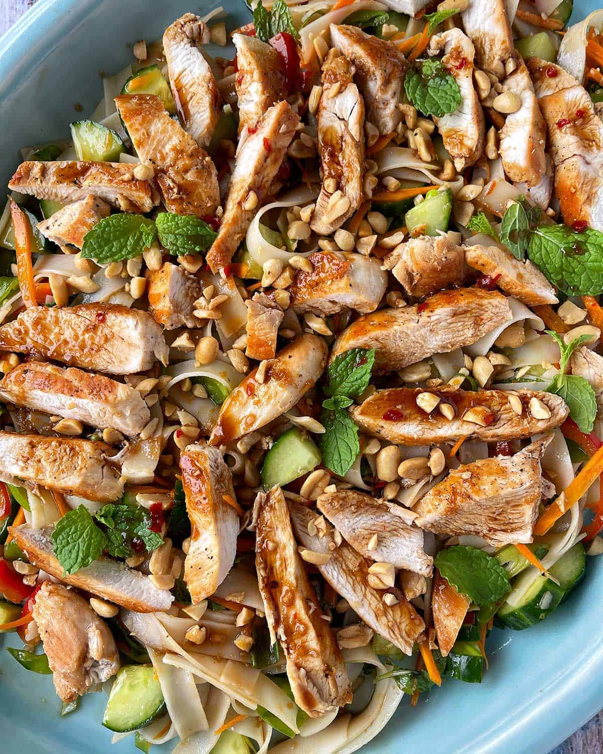 A close up of Thai Chicken Noodle Salad on a blue platter