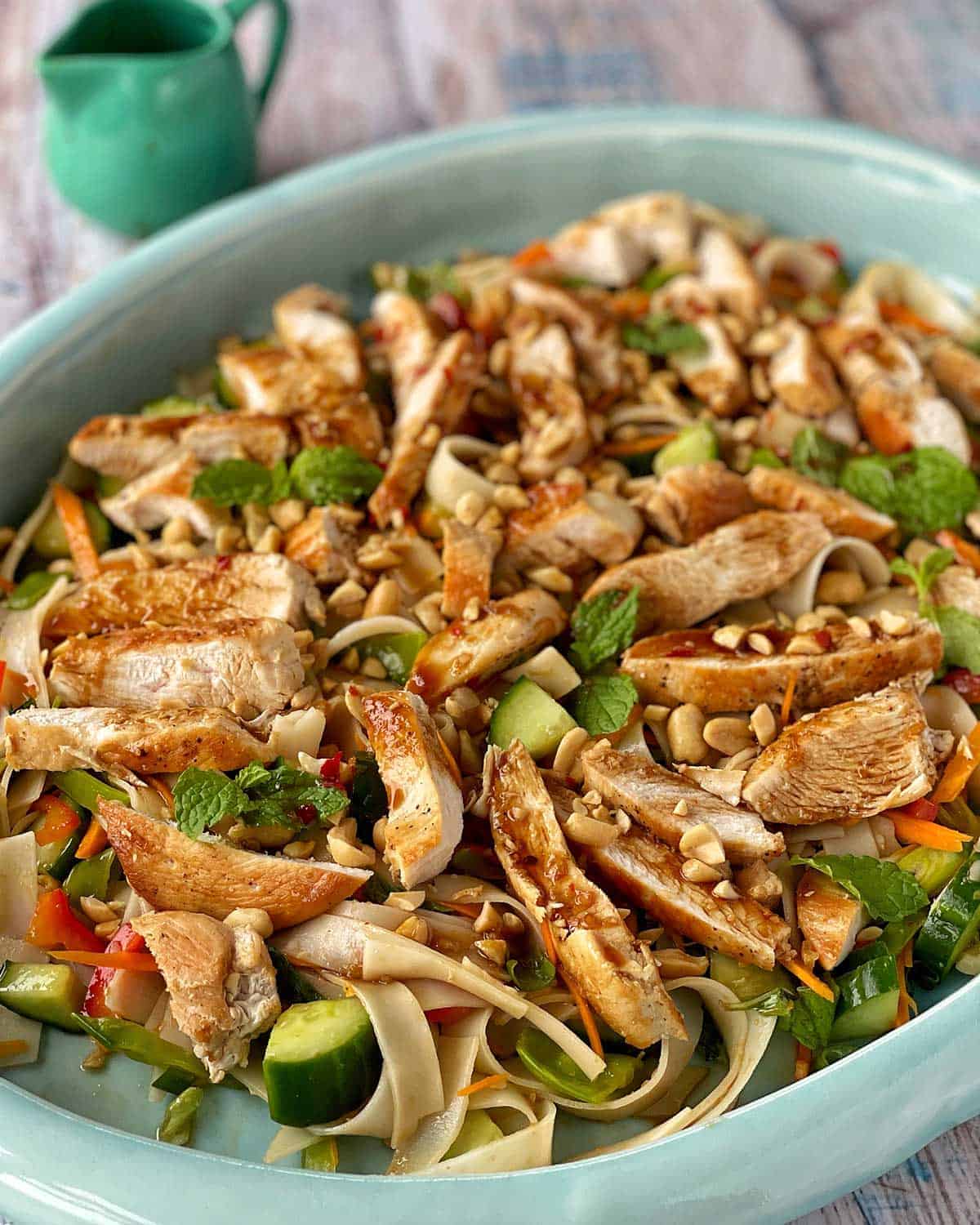 A close up of Thai Chicken Noodle Salad sitting on a large blue platter