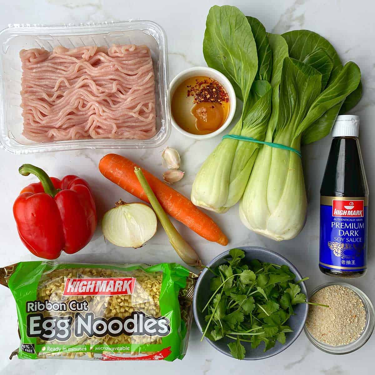 The ingredients for Chicken Meatballs with Noodles sitting on a white bench.