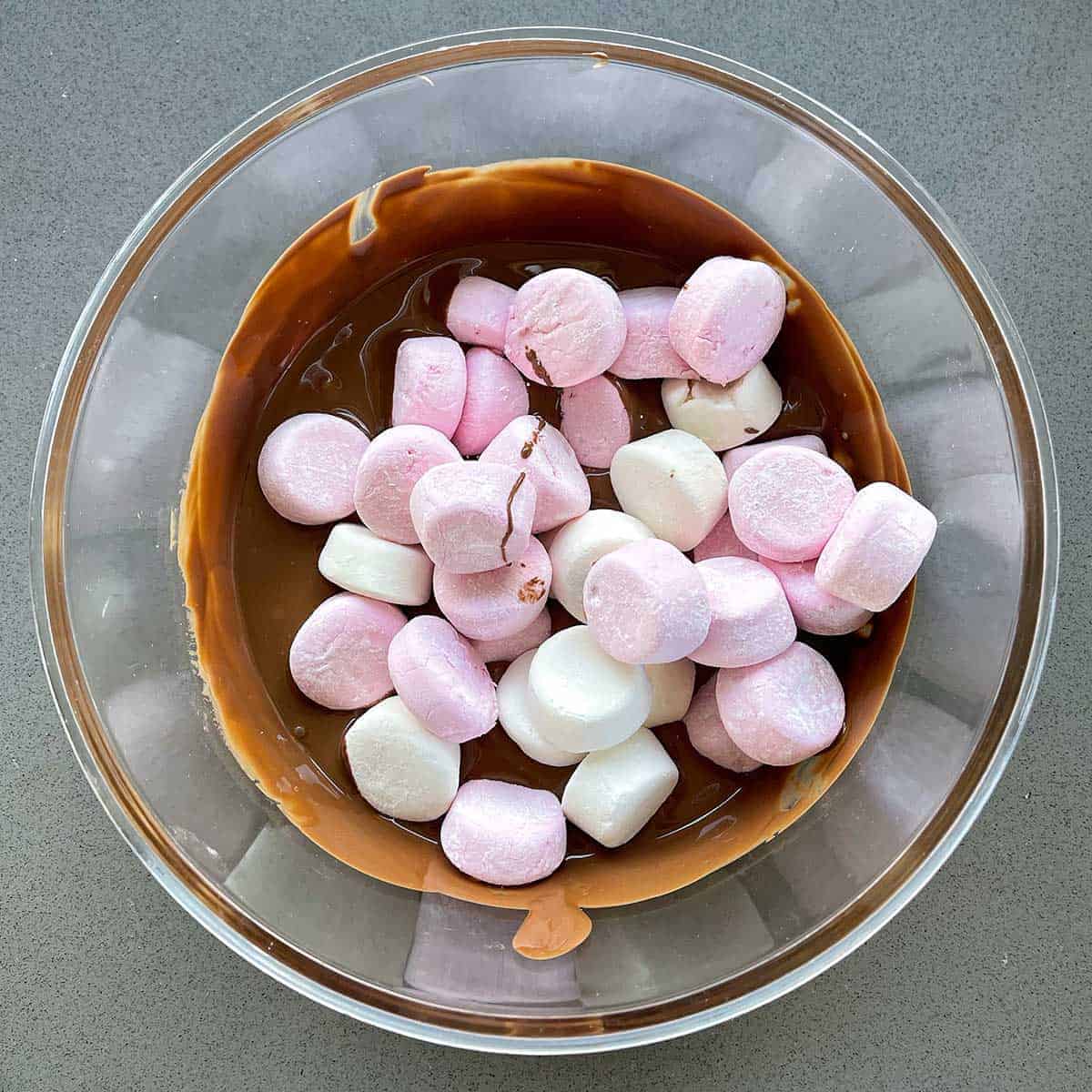 Marshmallows and melted chocolate in a glass bowl