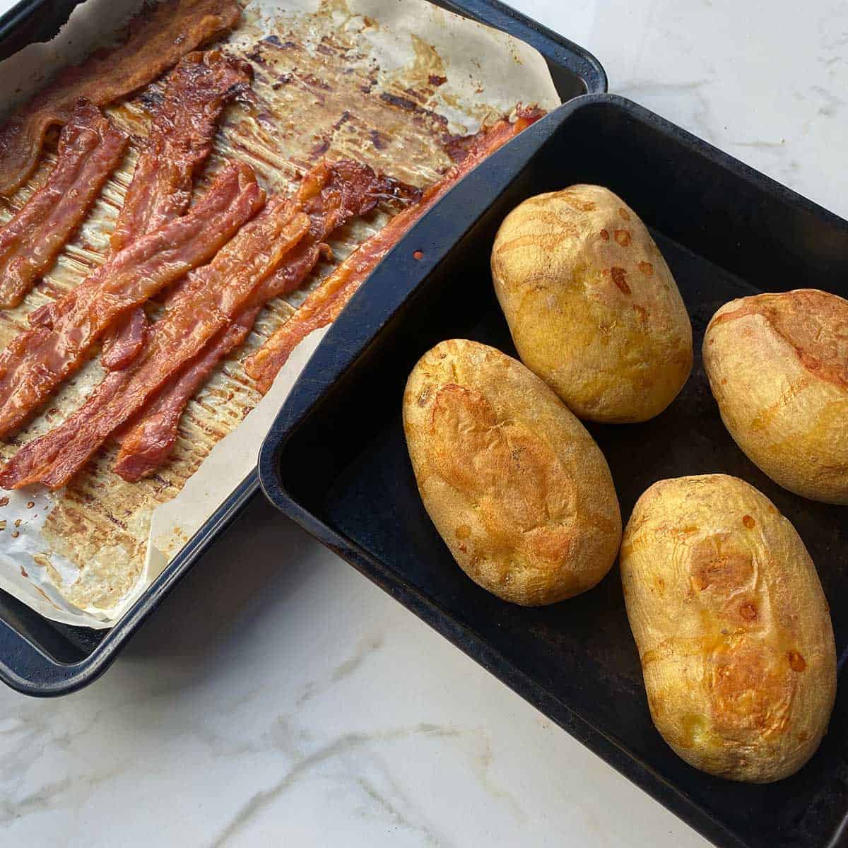 Cooked potatoes and bacon on a white marble bench.