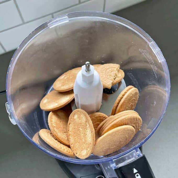 Easter Cheesecake Cups are on the horizon as biscuits are placed inside a food processor, ready to be crushed.