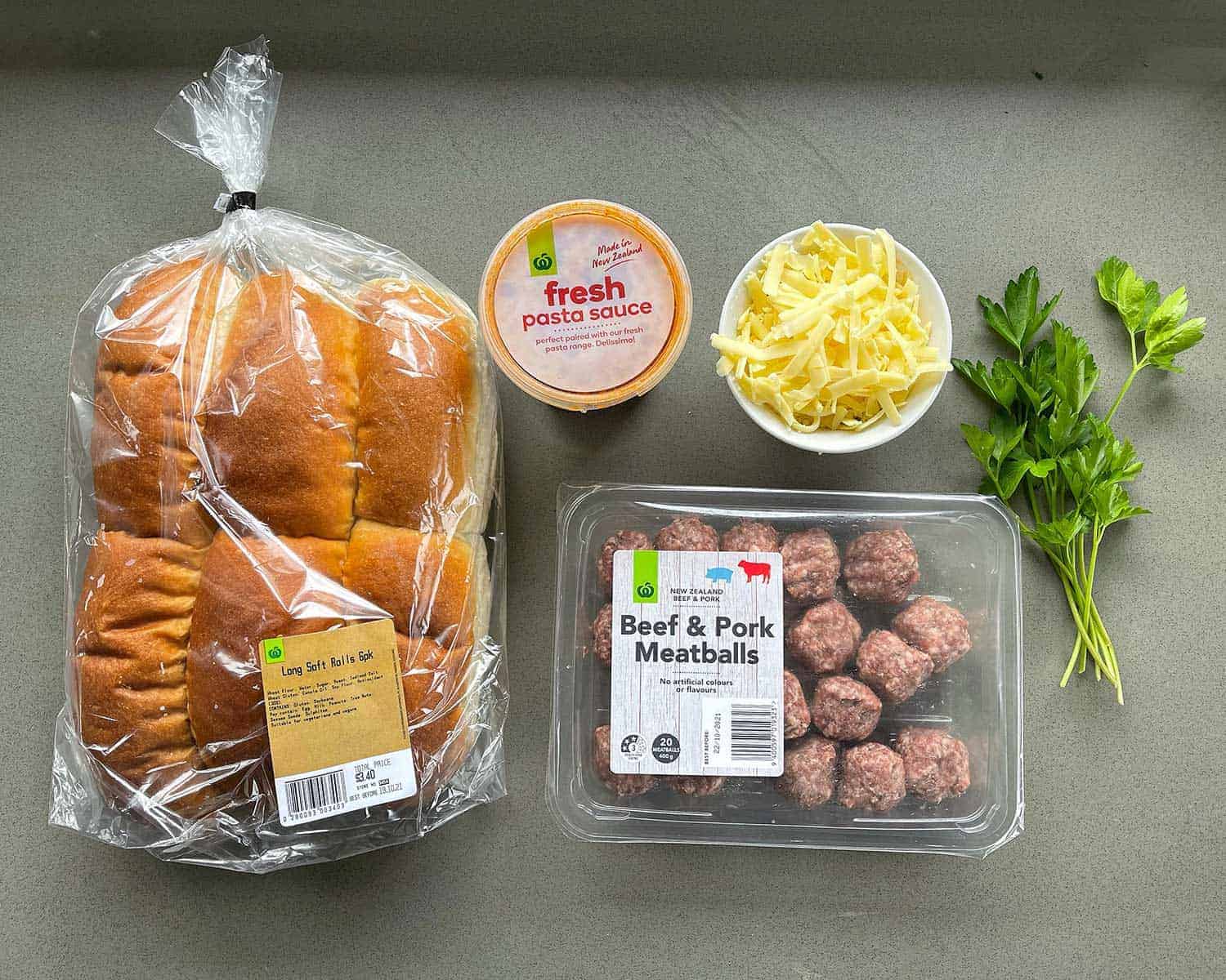 The ingredients for Meatball Subs on a grey bench.