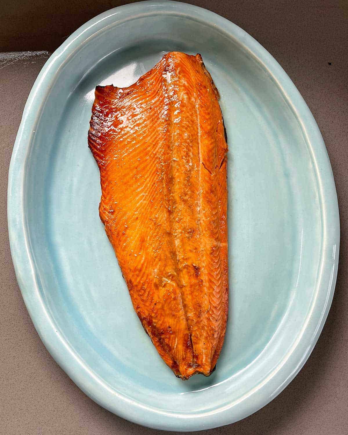 Cooked salmon on blue platter.
