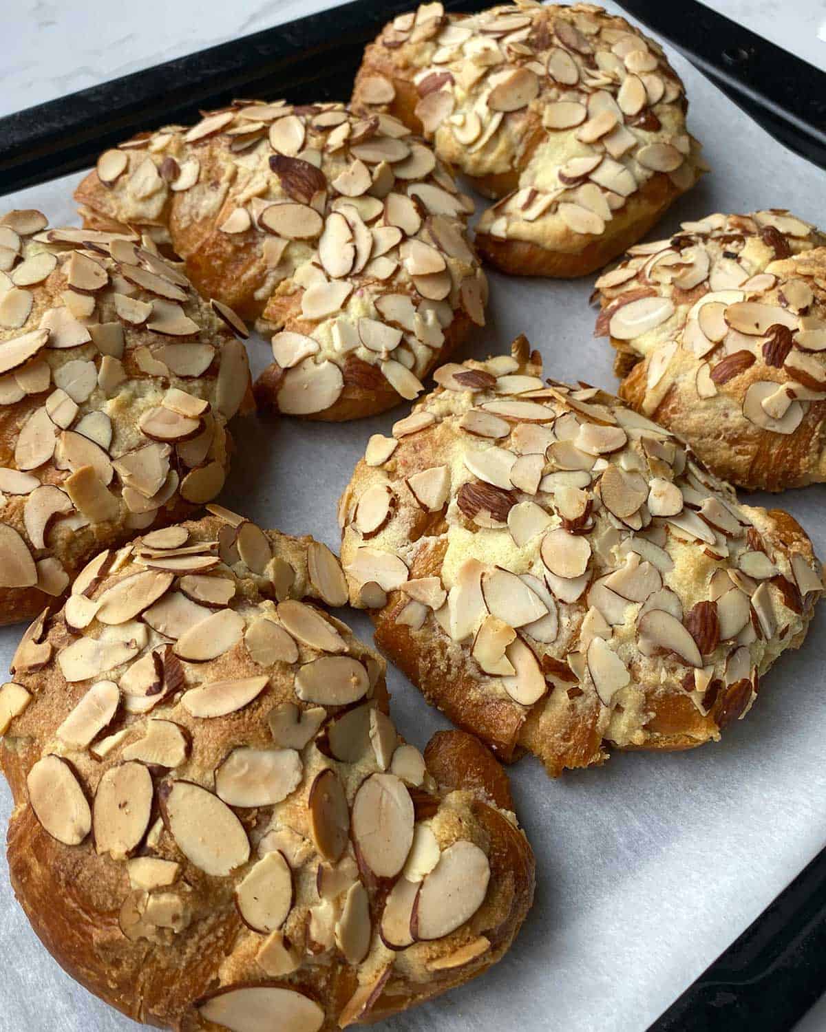 A tray of cooked Almond Croissants.