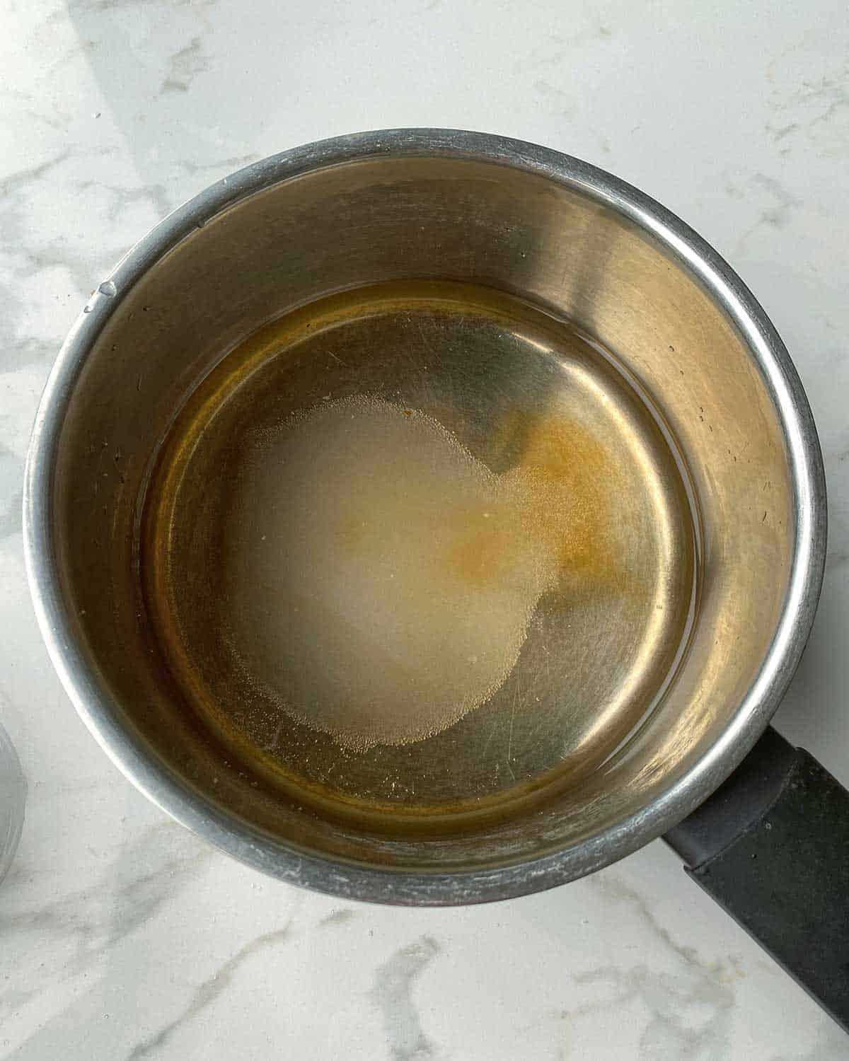 Water syrup and sugar in a saucepan.