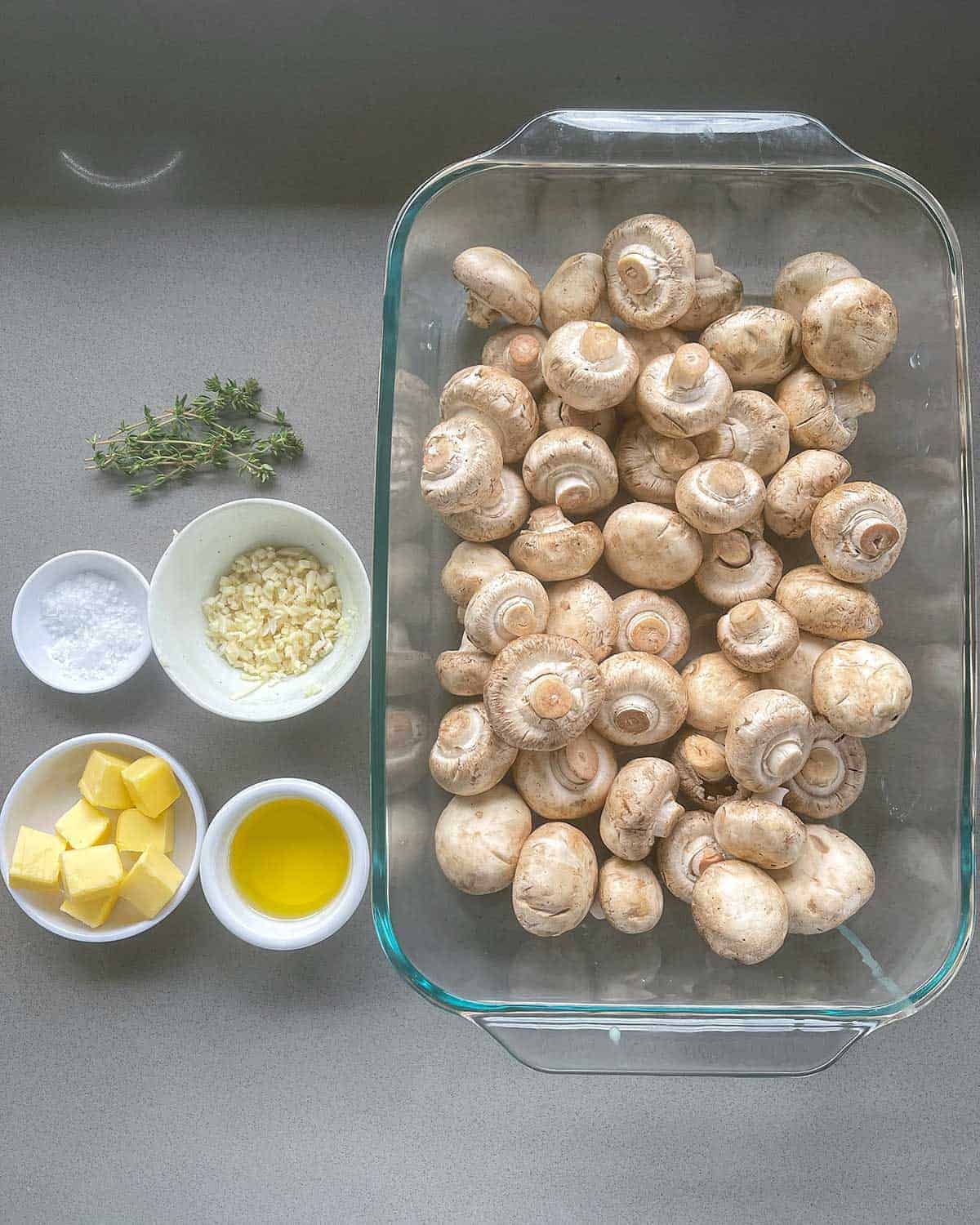 The ingredients for Baked Garlic Mushrooms on a grey bench.