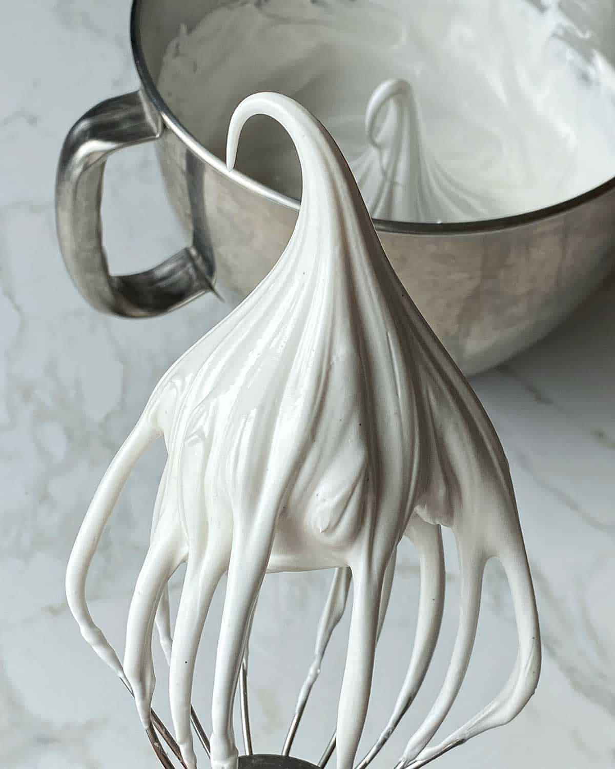 Whipped egg white on the end of a whisk attachment.
