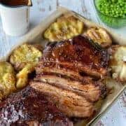 Slow cooked beef brisket on a large baking tray with masked potatoes on the side.
