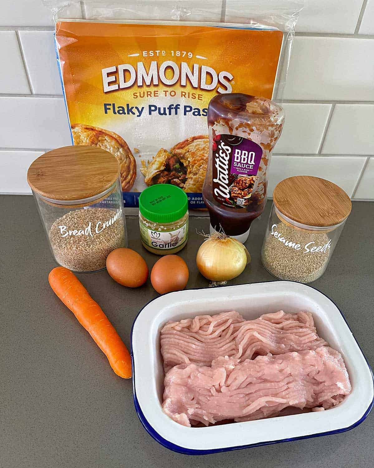 The ingredients for chicken sausage rolls on a grey bench.
