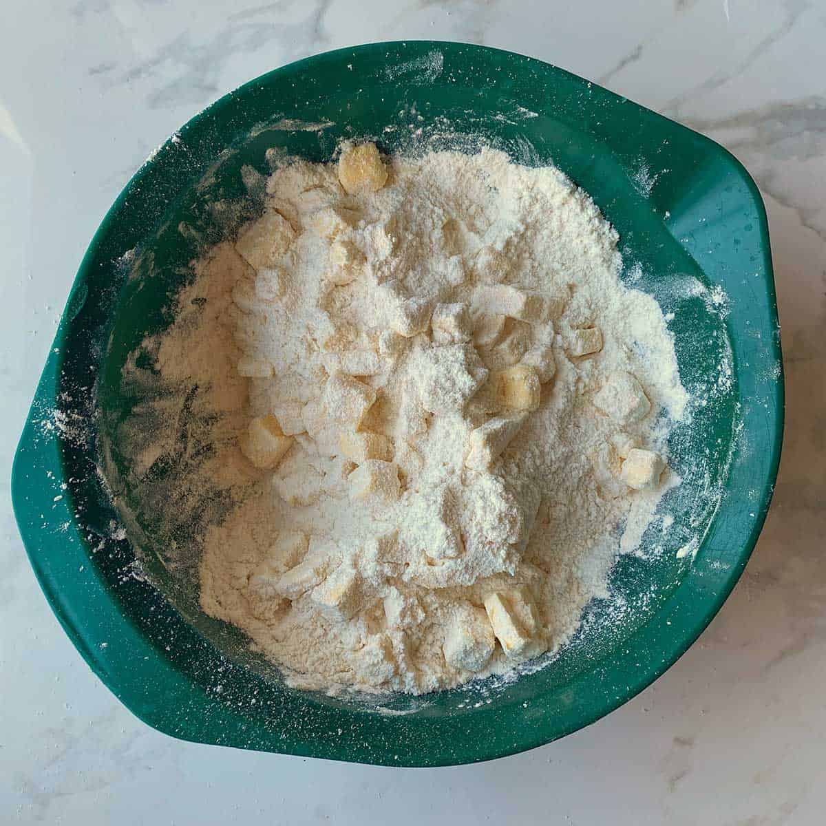 Butter and flour in a green bowl.