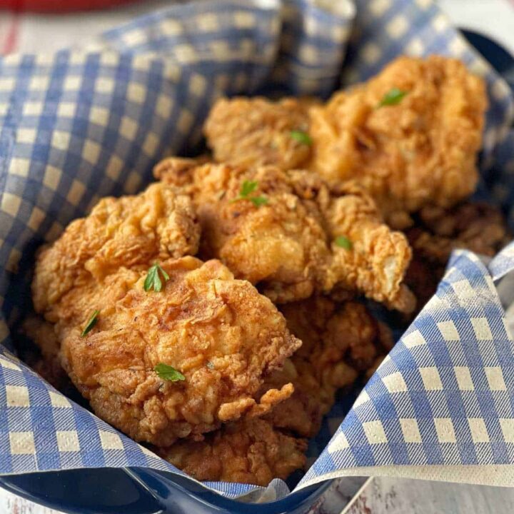 Southern fried chicken cooked and served in a dish lined with a blue and white napkin